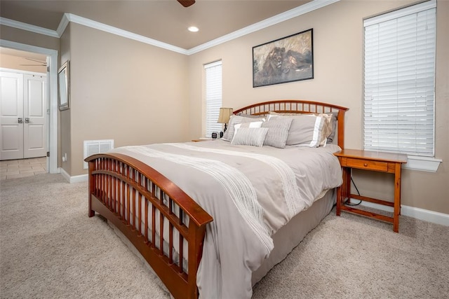 bedroom featuring light carpet, ceiling fan, and crown molding