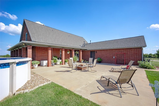 view of patio with a fenced in pool and a fire pit