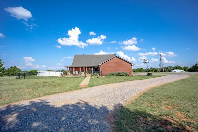 view of front of property featuring a front yard and a swimming pool