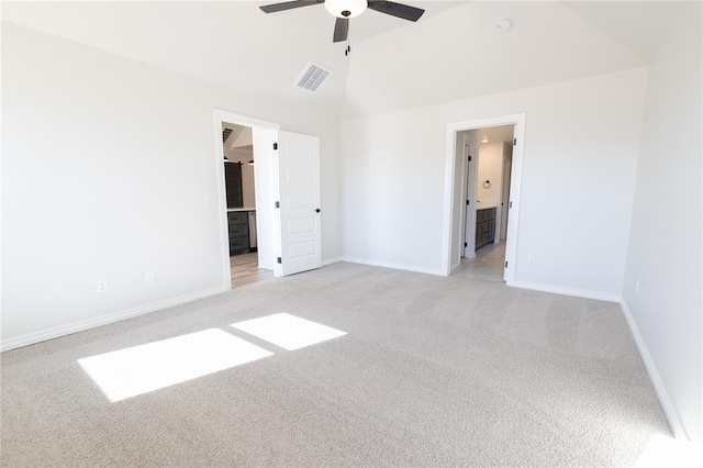 unfurnished bedroom featuring ceiling fan, light colored carpet, lofted ceiling, and ensuite bathroom