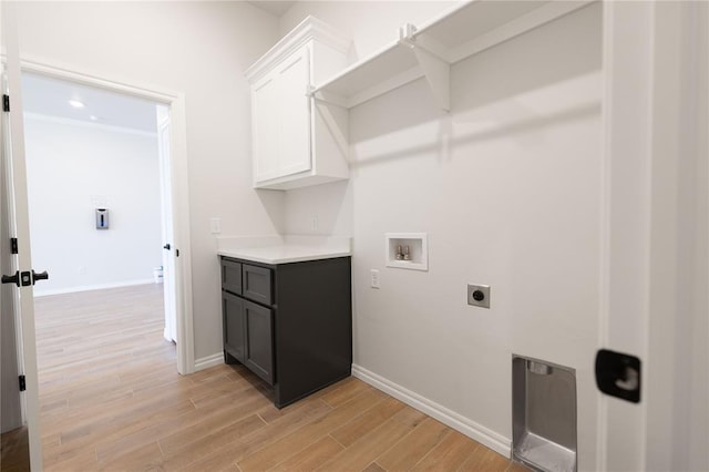 laundry room featuring electric dryer hookup, cabinets, washer hookup, and light hardwood / wood-style flooring