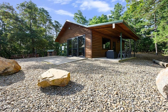 view of side of property with an outbuilding and a patio area