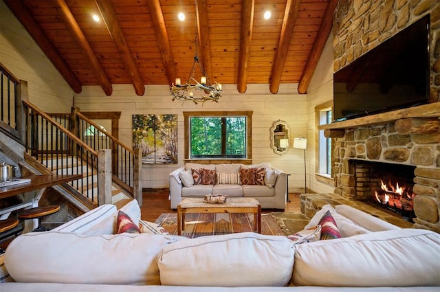 living room featuring hardwood / wood-style flooring, lofted ceiling with beams, a stone fireplace, and wood ceiling