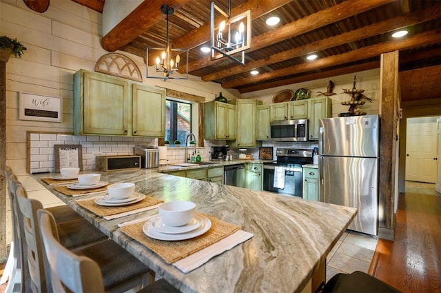 kitchen featuring kitchen peninsula, stainless steel appliances, sink, light hardwood / wood-style flooring, and beamed ceiling