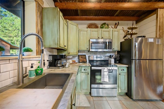 kitchen featuring tasteful backsplash, sink, beam ceiling, and appliances with stainless steel finishes