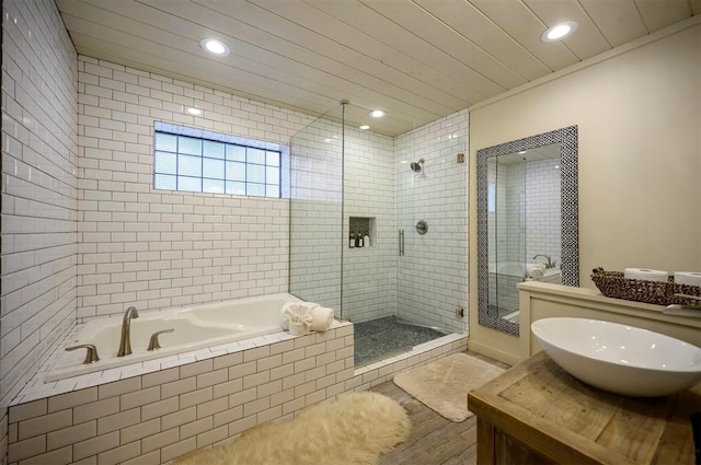 bathroom with vanity and shower with separate bathtub