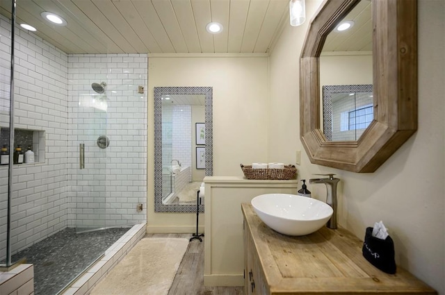 bathroom featuring hardwood / wood-style flooring, vanity, and a shower with door