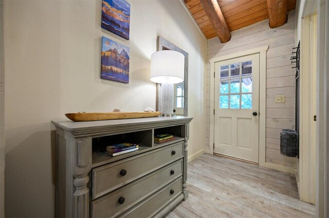 doorway to outside with vaulted ceiling with beams, wood walls, light hardwood / wood-style flooring, and wooden ceiling