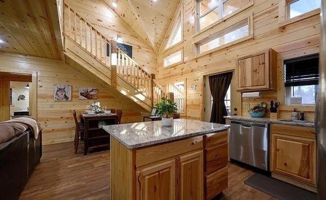 kitchen featuring dark hardwood / wood-style flooring, wooden walls, dishwasher, and a center island