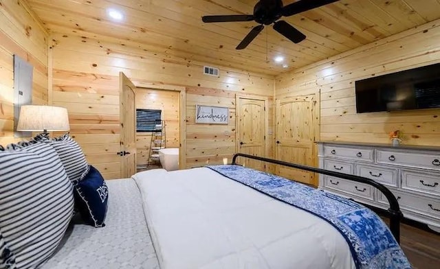 bedroom with ensuite bath, wooden ceiling, and wood walls