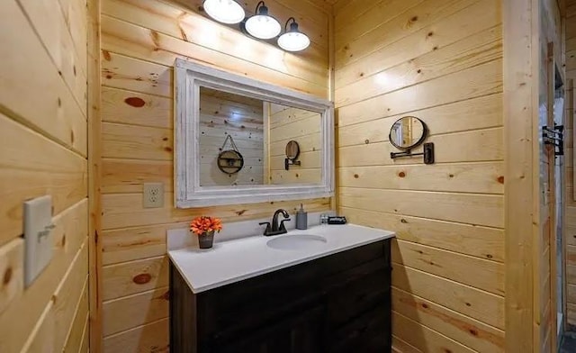 bathroom featuring vanity and wooden walls