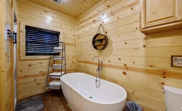 bathroom with a bathtub, hardwood / wood-style flooring, wooden ceiling, toilet, and wood walls