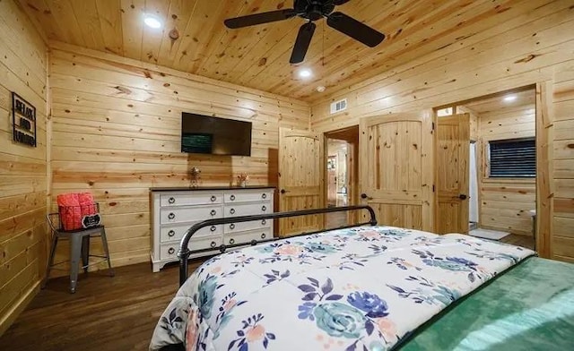 bedroom with wood walls, dark hardwood / wood-style flooring, ceiling fan, and wooden ceiling