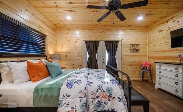 bedroom with ceiling fan, dark hardwood / wood-style flooring, wood ceiling, and wooden walls