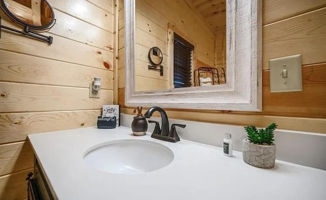 bathroom with vanity and wooden walls