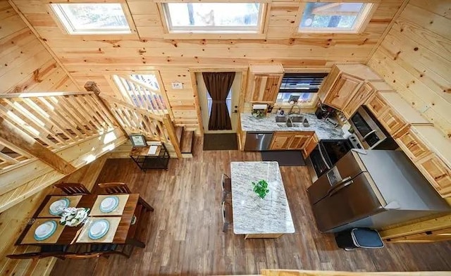 interior space with hardwood / wood-style floors, lofted ceiling, and wooden walls