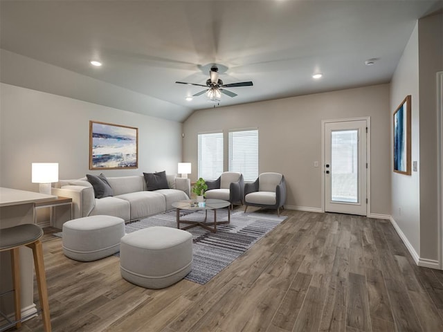 living room featuring ceiling fan, wood-type flooring, and vaulted ceiling