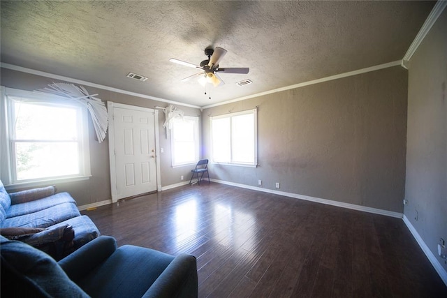 unfurnished living room with ceiling fan, dark hardwood / wood-style flooring, a textured ceiling, and crown molding