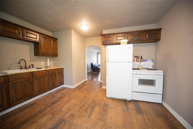 kitchen with a textured ceiling, white appliances, dark hardwood / wood-style floors, and sink