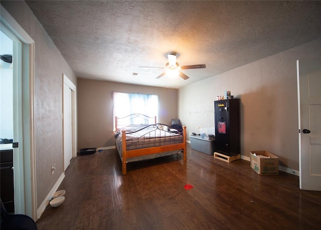 bedroom featuring a textured ceiling, dark hardwood / wood-style flooring, and ceiling fan