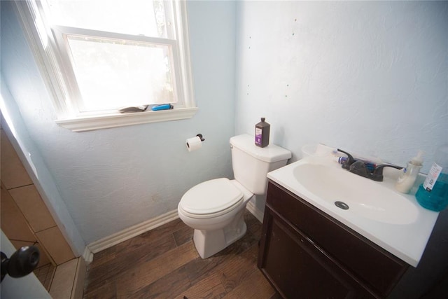 bathroom with toilet, vanity, and hardwood / wood-style flooring