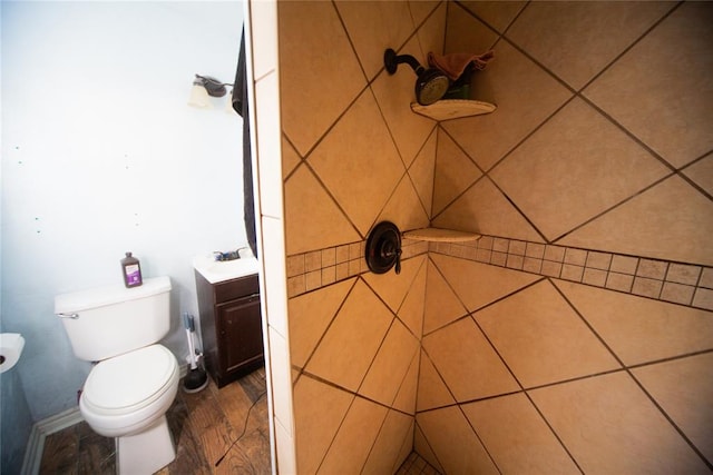 bathroom with a tile shower and toilet