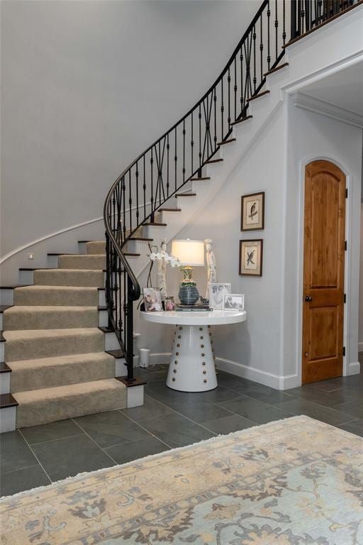 stairway featuring tile patterned floors and crown molding