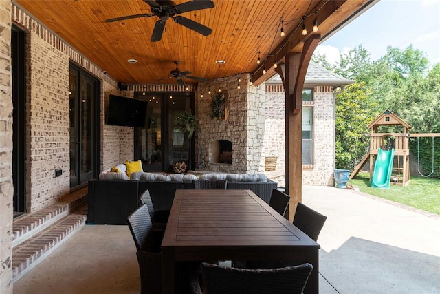 view of patio / terrace with an outdoor living space with a fireplace and a playground