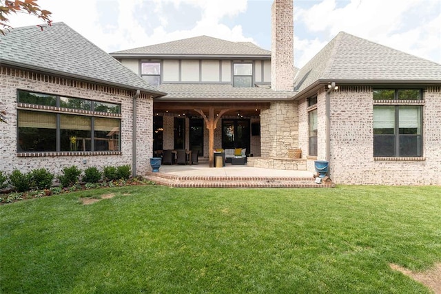 rear view of house featuring a lawn and a patio area