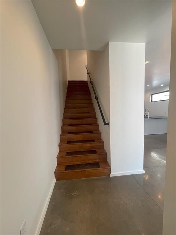 stairs featuring concrete flooring