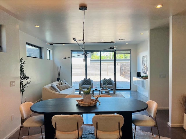 dining space featuring wood-type flooring and an inviting chandelier