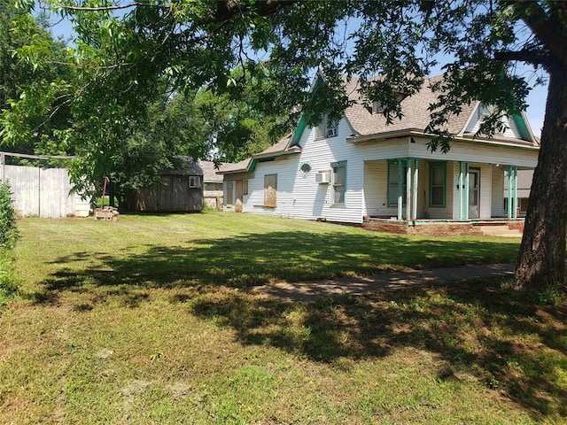 view of yard with a porch and a wall mounted AC