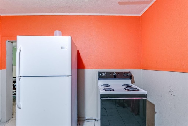 kitchen featuring a textured ceiling, crown molding, light tile patterned flooring, and white appliances