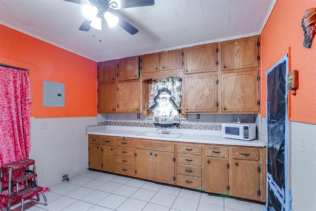 kitchen featuring electric panel, ceiling fan, ornamental molding, and sink