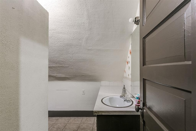 bathroom featuring tile patterned flooring, vanity, and a textured ceiling