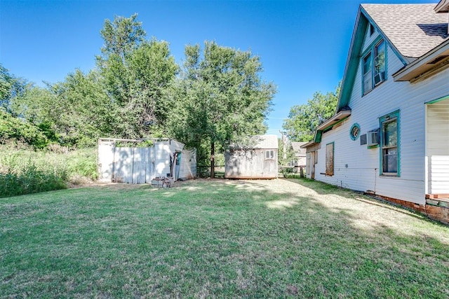 view of yard featuring a wall mounted AC and a storage unit