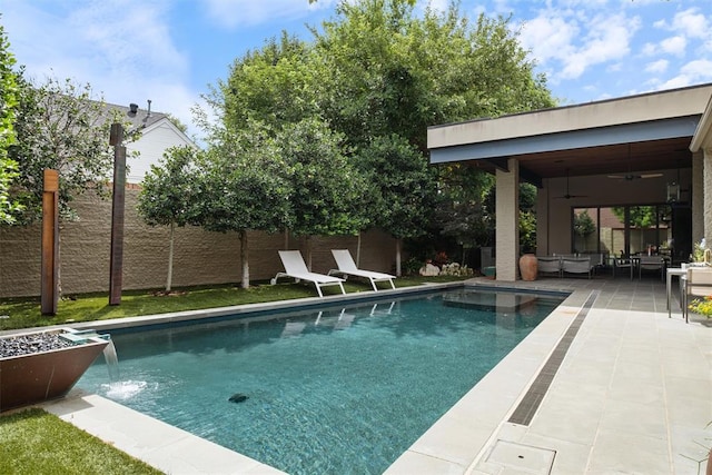 view of swimming pool with a patio area, ceiling fan, and pool water feature