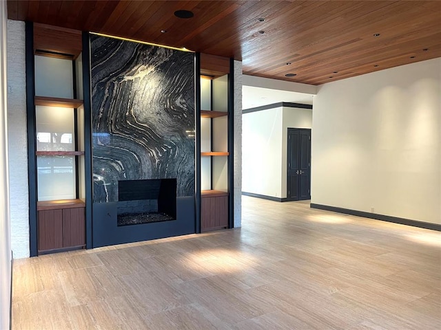 unfurnished living room featuring a fireplace, wooden ceiling, and light hardwood / wood-style floors