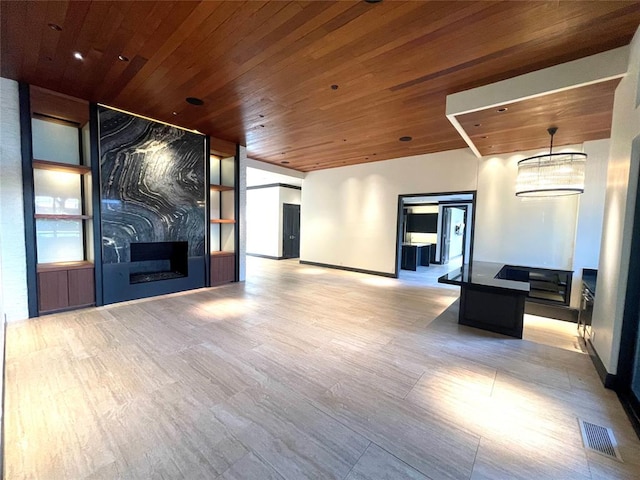 unfurnished living room with a large fireplace, light wood-type flooring, and wood ceiling