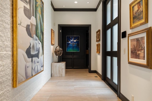 hallway with light wood-type flooring and ornamental molding