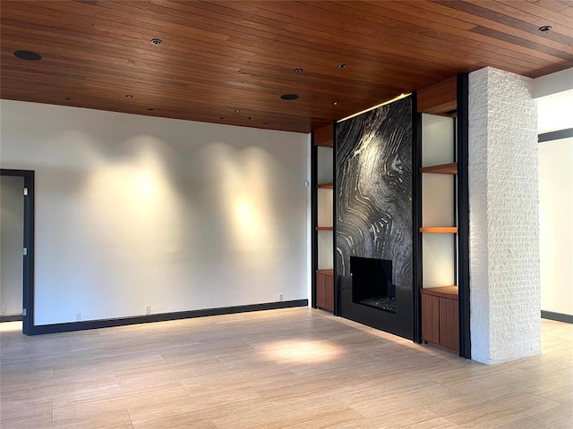 home theater room featuring a large fireplace, light hardwood / wood-style flooring, and wooden ceiling