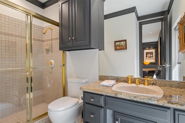 bathroom featuring vanity, toilet, a shower with shower door, and ornamental molding