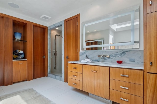 bathroom with tile patterned floors, decorative backsplash, a shower with door, and vanity