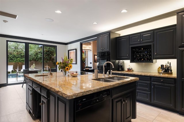 kitchen with light stone countertops, crown molding, sink, black appliances, and an island with sink