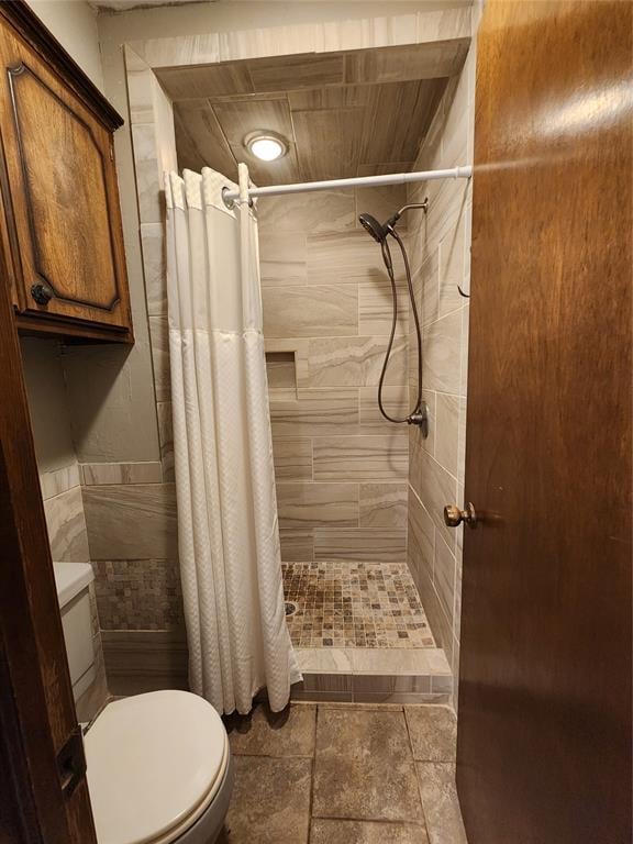 bathroom with toilet, tile walls, and walk in shower