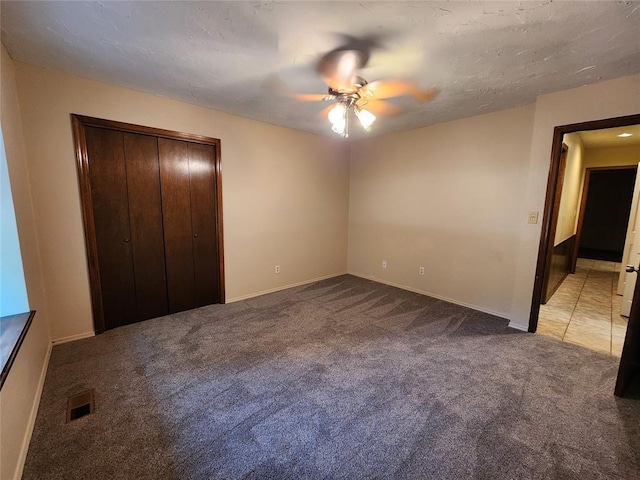 unfurnished bedroom with light carpet, a closet, and ceiling fan