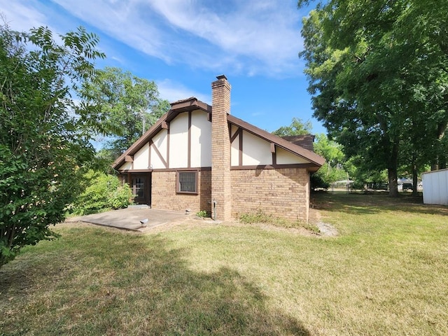 1116 Reid Cir, Seminole, OK 74868 - back of house featuring a patio, a chimney, a yard, and brick siding