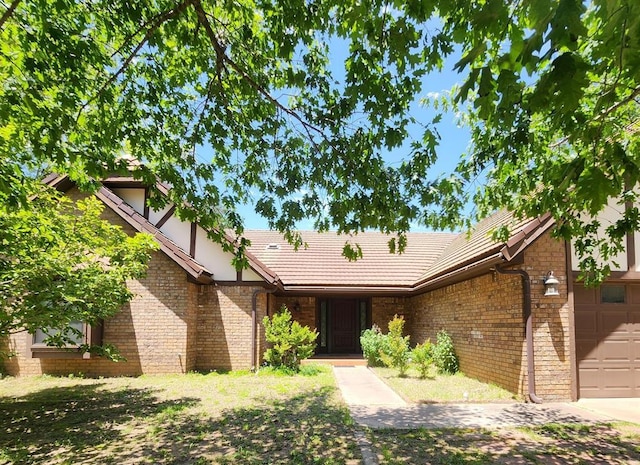 1116 Reid Cir, Seminole, OK 74868 - view of front of home with a tile roof, an attached garage, and brick siding