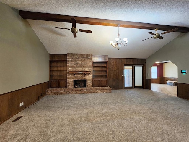 1116 Reid Cir, Seminole, OK 74868 - unfurnished living room with a ceiling fan, wood walls, arched walkways, carpet flooring, and a fireplace