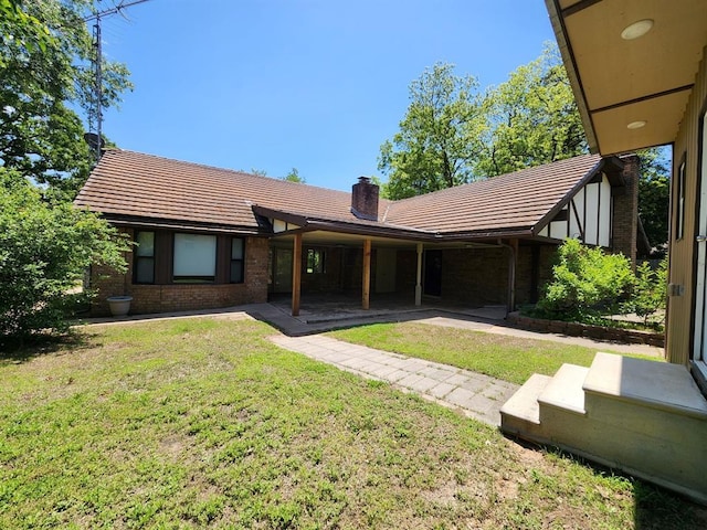 1116 Reid Cir, Seminole, OK 74868 - rear view of property with a tile roof, a yard, and a chimney